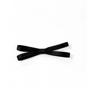 Elegant black satin bow hair clip with minimalist ribbon design on white background
