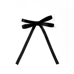 Detail showing the smooth texture and elegant weave of the black satin ribbon bow clip