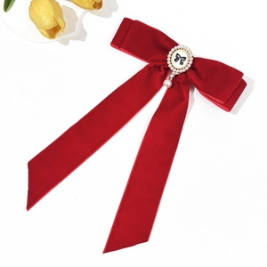 Detail of red velvet bow hair clip featuring pearl pendant and elegant retro ribbon design