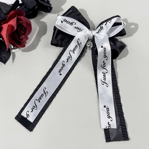 Détail d'un nœud papillon gothique avec pendentif cœur en strass et ruban satiné