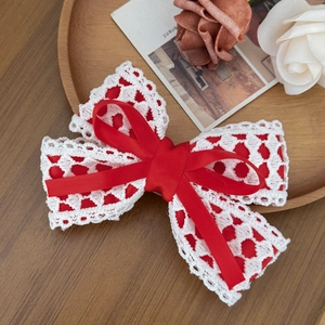 Detailed macro view of red satin ribbon layered over white floral hollow lace bow