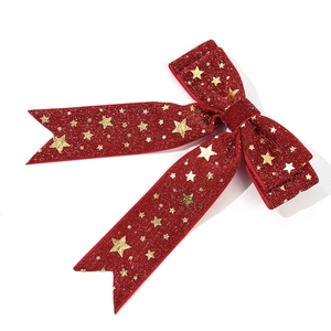 Primer plano de lazo de Navidad de terciopelo rojo con estrellas doradas brillantes