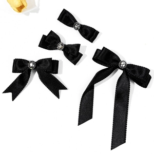 Black satin bow hair clips with rhinestones in four sizes on a white background