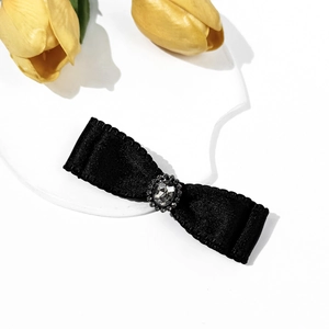 Detailed view of black satin bow hair clip with vintage silver crystal centerpiece
