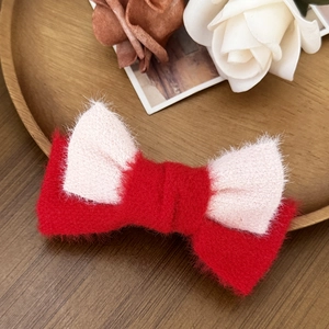 Elegante fermaglio per capelli in peluche bianco e rosso su vassoio di legno decorato