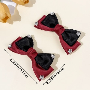 Detail view of burgundy and black satin bow hair clips with star-shaped rhinestones