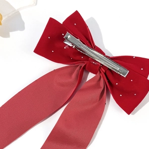 Elegant red velvet bow hair clip with rhinestones and long streamers on white background