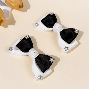 Close-up of black and white bow hair clips with sparkling star rhinestones on satin