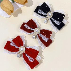 Red and black velvet lace bow hair clips with pearls and rhinestones on beige background