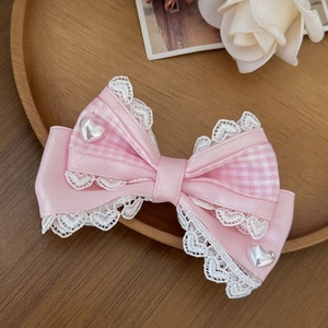 Roze Lolita strik haarspeld met kant en parel hart accenten op houten dienblad