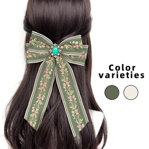 Bohemian bow hair clip with green floral embroidery and emerald gemstone centerpiece