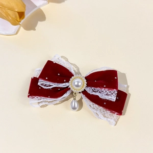 Detail of red velvet Christmas bow hair clip with white lace, pearls and droplet pendant