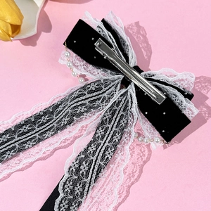 French vintage velvet bow hair clip with lace edges and pearl pendant on pink background