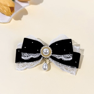 Macro view of velvet lace bow hair clip featuring pearl pendant and rhinestone detail