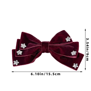 Detailed view of burgundy velvet bow hair clip with star accents and size measurements