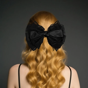 Detailed back view of a large black lace and satin bow hair clip on golden wavy hair
