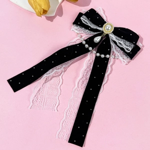 Detail of vintage black velvet bow hair clip with white lace trim and pearl pendant chain
