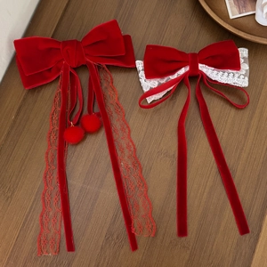 Elegant red velvet bow hair clips with lace trim and plush balls on wooden tray