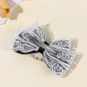 Barrette à cheveux Lolita avec dentelle, perles blanches et nœud sur fond beige