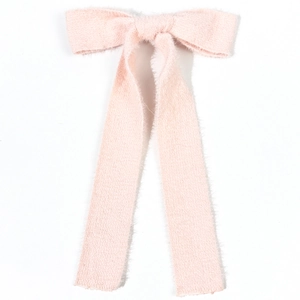 Pink woolen bow hair clip with long ribbons featuring soft knit texture and minimalist style