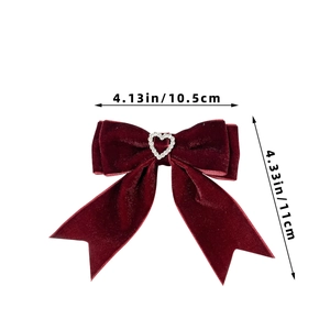 Detailed view of velvet bow hair clip featuring a sparkling heart rhinestone center