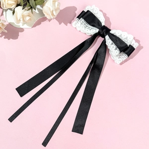 Détail du nœud papillon en dentelle élégant avec de longs rubans noirs pour cheveux