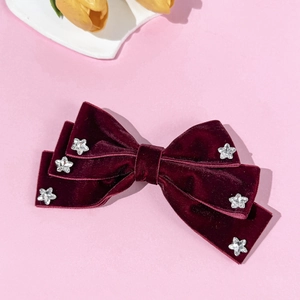 Detail view of wine red velvet bow hair clip with sparkling star rhinestones decoration