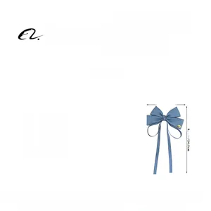 Detail showing blue denim ribbon bow hair clip with long tassels weighing 12.4g