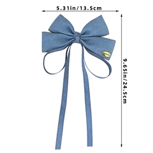 Blue denim bow hair clip with long ribbons and a gold Chanceux metal tag detail