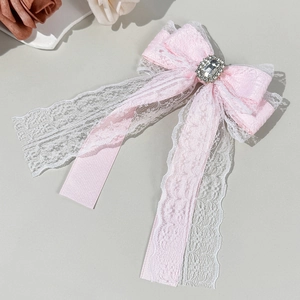 Vue détaillée de la pince à cheveux nœud en dentelle rose avec strass rectangulaire