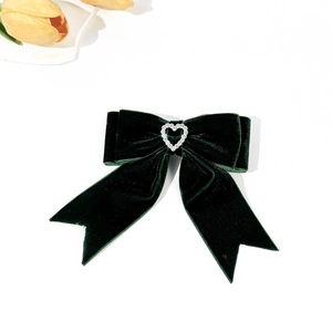 Detail of dark green velvet bow hair clip with heart rhinestone and long ribbons