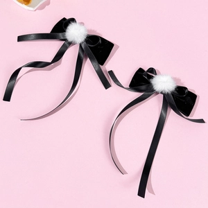 Dettaglio di fermagli per capelli in nastro nero stile balletto con pompon e lunghe nappe