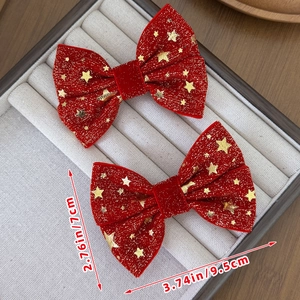 Coppia di fermagli a fiocco in velluto rosso con stelle dorate per acconciature natalizie