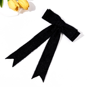 Detail view of the elegant black velvet bow hair clip with long streamer ribbons