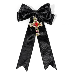 Détail du nœud en satin noir avec croix dorée et pierres précieuses multicolores