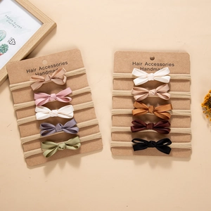 Detail of 5-piece baby headband set showing elastic nylon bands and fabric bows