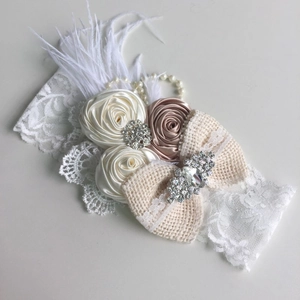 Détail du bandeau en dentelle avec roses en satin, nœud en lin et perles élégantes