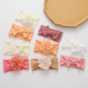 Close-up of soft nylon baby headbands with chiffon flowers and bows in pastel colors