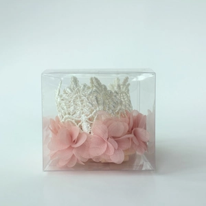 Lace crown headband for babies with pink chiffon floral details in a transparent gift box