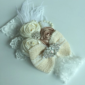 Détail de fleurs de satin, nœud en toile de jute et perles sur le bandeau en dentelle