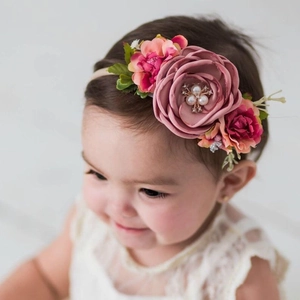 Détail du bandeau floral pour bébé avec roses en tissu rose et décor de perles