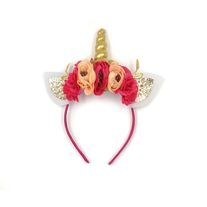 Dettaglio del cerchietto unicorno con corno dorato, fiori rosa e orecchie glitterate