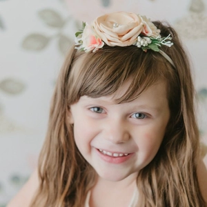 Détail d'un bandeau floral rose pour bébé avec pétales doux et centre en perle