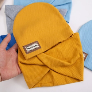 Detail of knit hat and neck warmer set with ribbed texture and handmade leather label