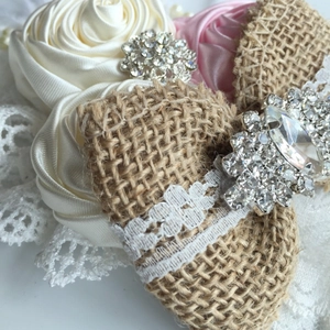 Détail du bandeau bébé avec roses en satin, nœud en toile, dentelle et strass brillants