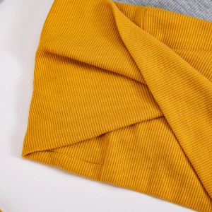 Detailed close-up of ribbed knit texture in mustard yellow and grey for winter warmth