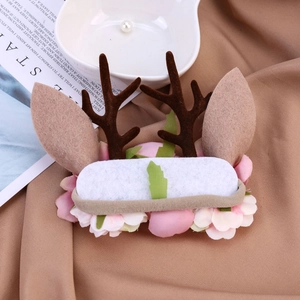 Détail d'un bandeau de Noël avec bois de renne, fleurs artificielles et feuilles vertes