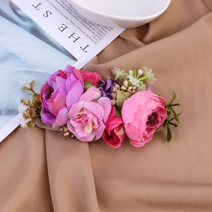 Detailansicht von floralem Haarschmuck mit bunten Stoffblumen und kleinen Goldperlen