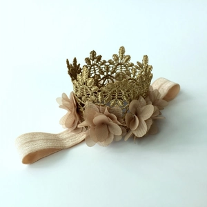 Detailed close-up of golden lace crown and soft chiffon flowers on elastic baby headband