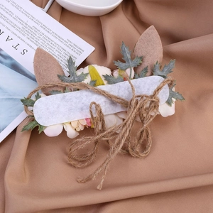Détail du bandeau renne de Noël avec fleurs artificielles et accents de corde en chanvre